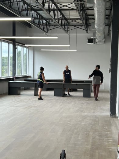 Trois déménageurs installant des bureaux dans un nouvel espace de travail à aire ouverte