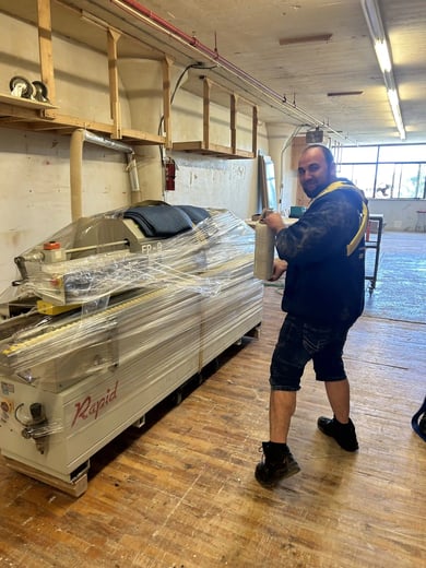 Mover wrapping an industrial machine in protective film before it leaves the workshop Mover wrapping an industrial machine in protective film before it leaves the workshop