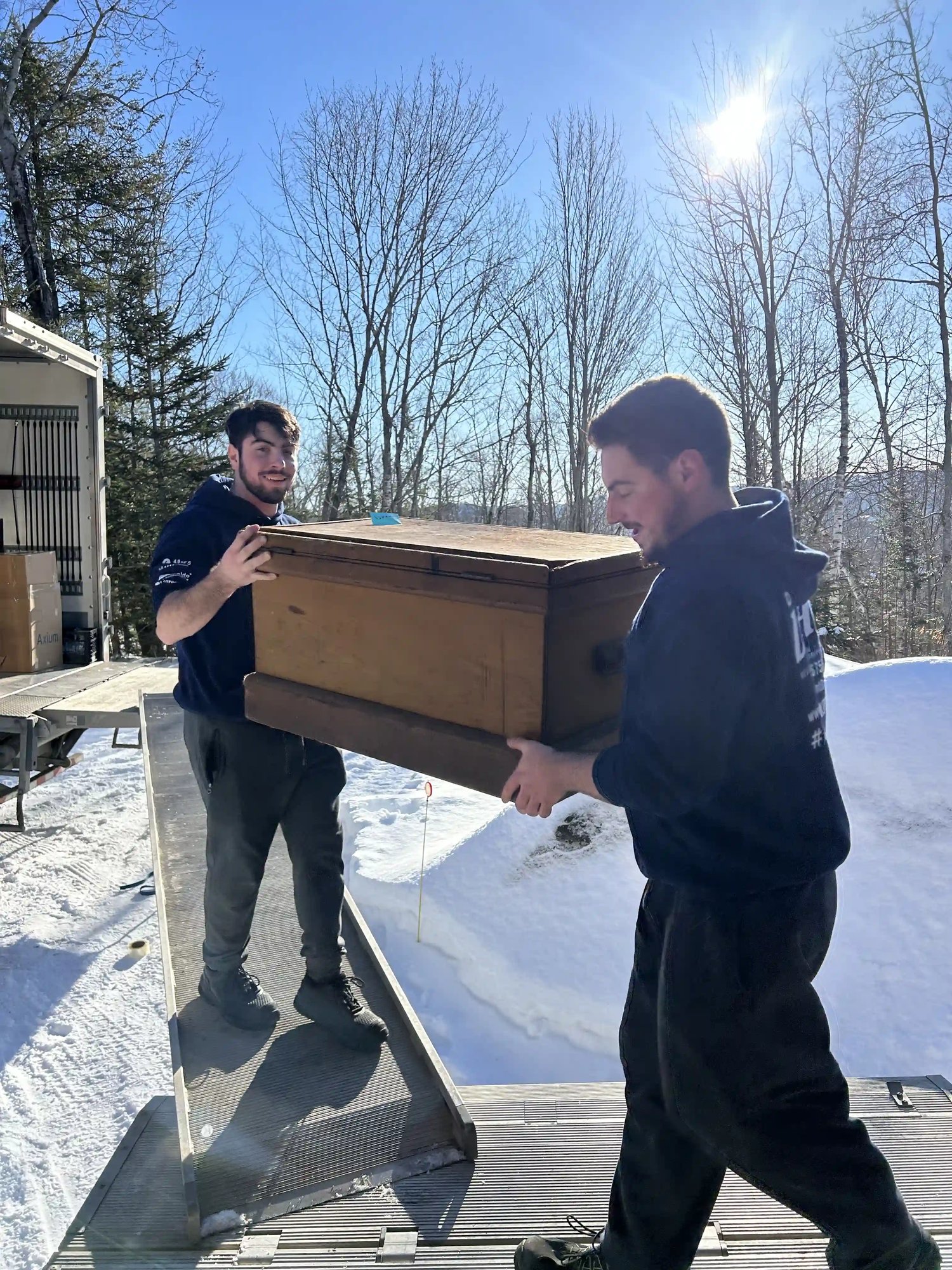 Déménageurs de DMAX transportant un meuble en bois lors d’un déménagement entre Terrebonne et Mascouche en hiver