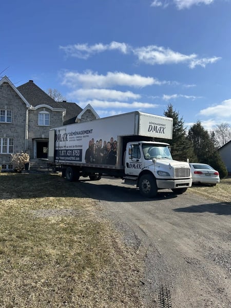 Best Mover in Montreal: DMAX moving truck parked in front of a house, ready for a long-distance residential moving service.