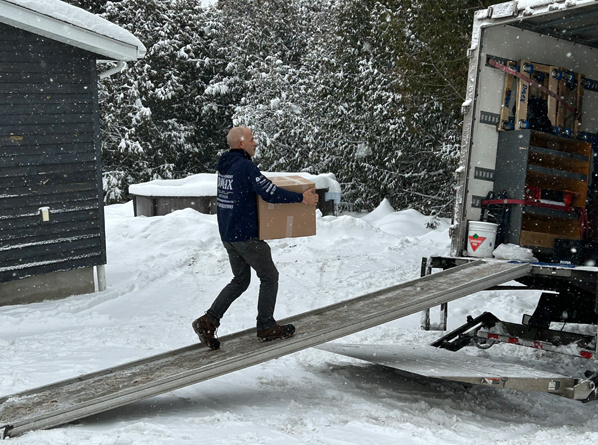 compagnie déménagement montreal - Un déménageur monte dans la camion de déménagement avec un carton