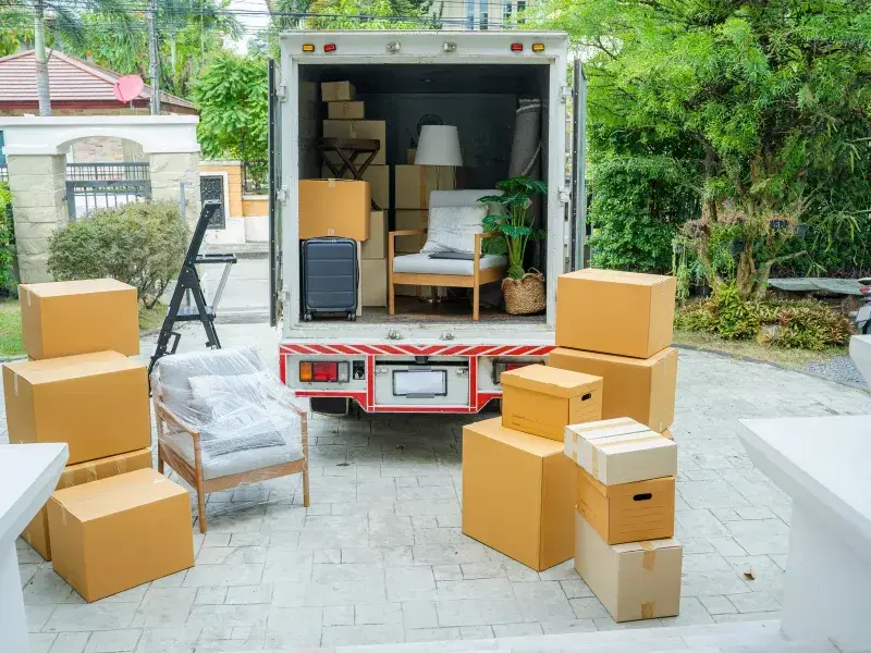 déménagement clé en main Laval - Camion de déménagement ouvert avec meubles et boîtes empilées devant une maison 