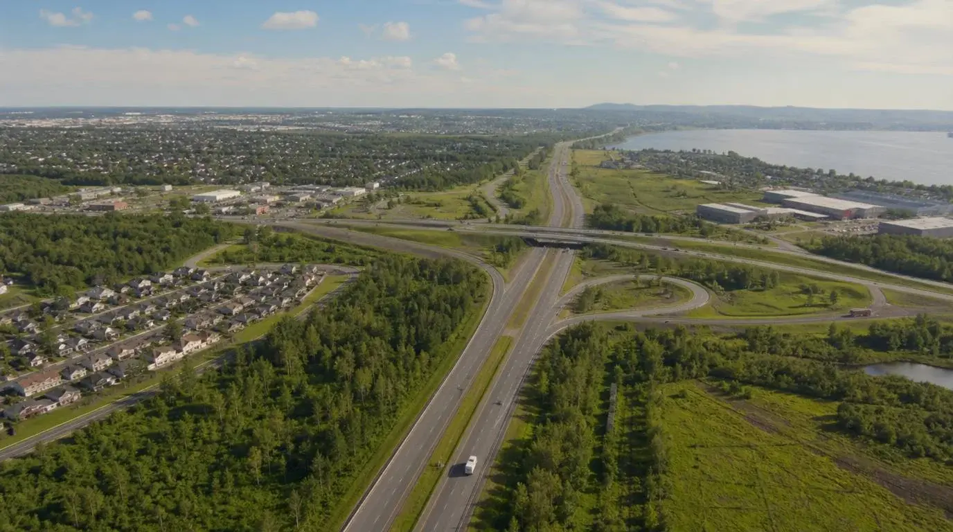 Vue aérienne d'un échangeur autoroutier à Laval avec la rivière des Prairies en arrière-plan, illustrant les déménagements longue distance depuis Laval