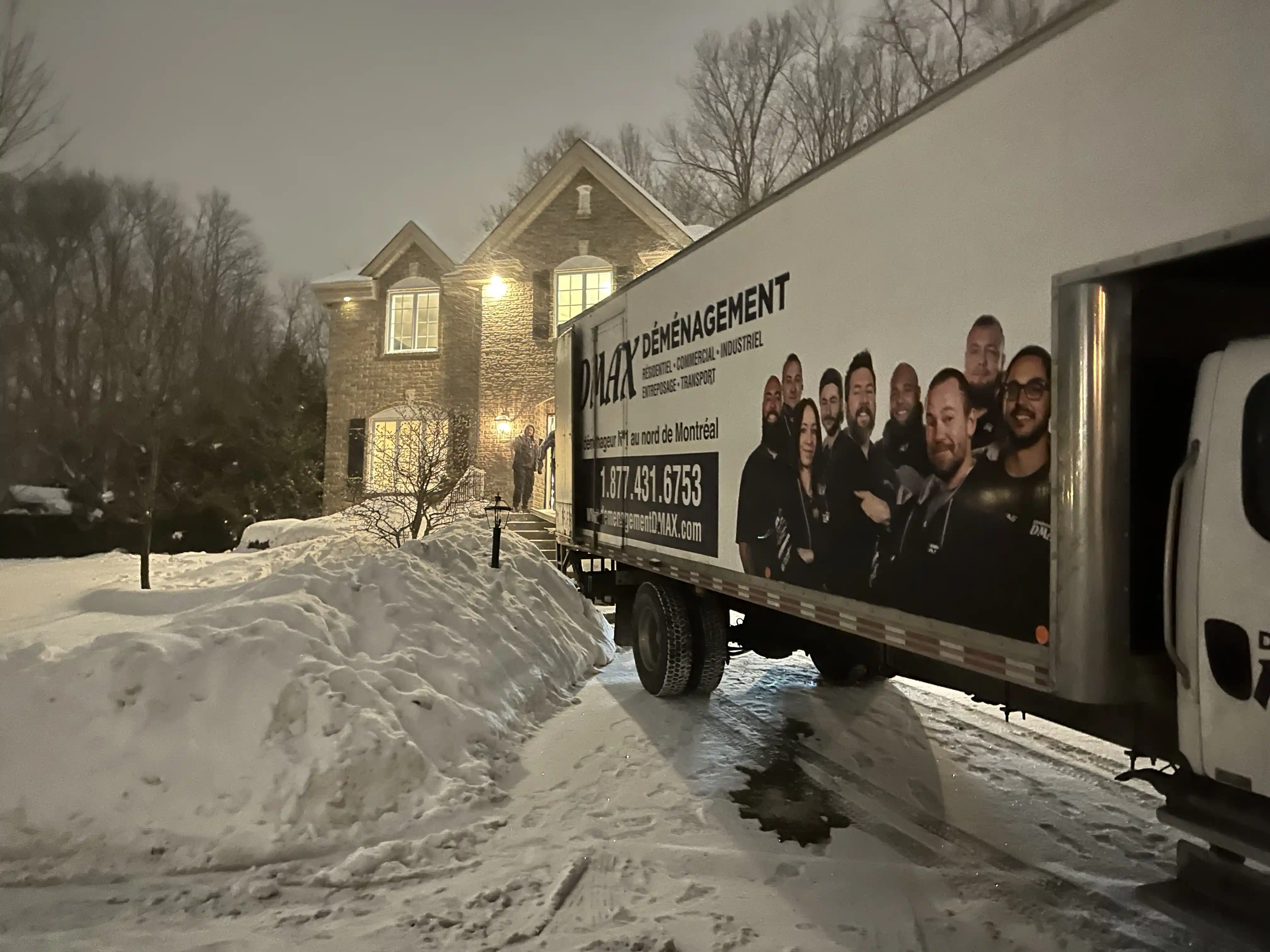 Camion de DMAX Déménagement stationné devant une maison en hiver à Mirabel, prêt pour un déménagement résidentiel