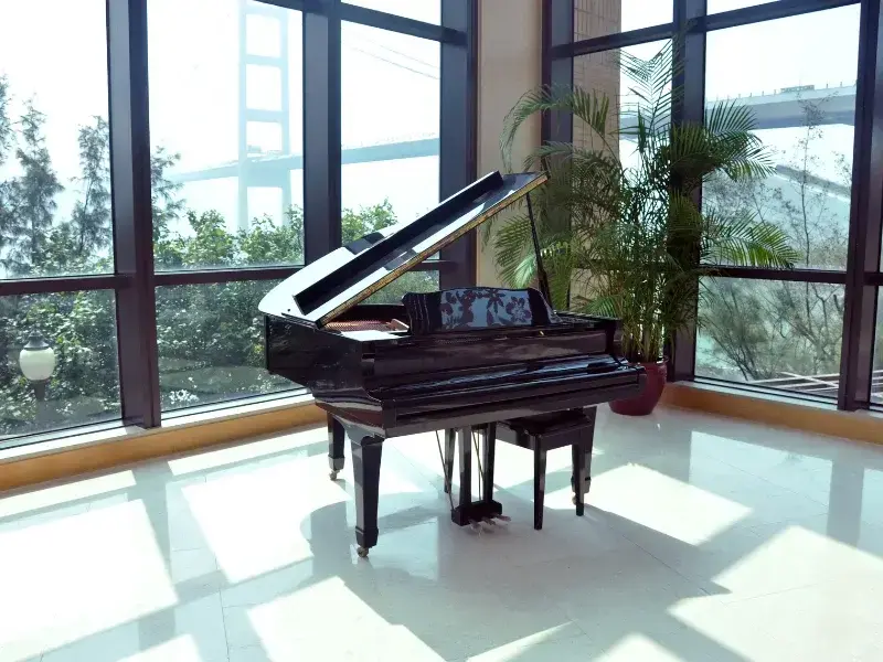 Déménagement piano Laval - Piano à queue noir installé dans une pièce lumineuse avec baies vitrées