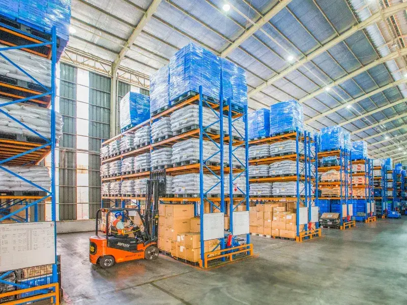 Déménagement commercial Laval - Entrepôt logistique avec rayonnages industriels et chariot élévateur en opération