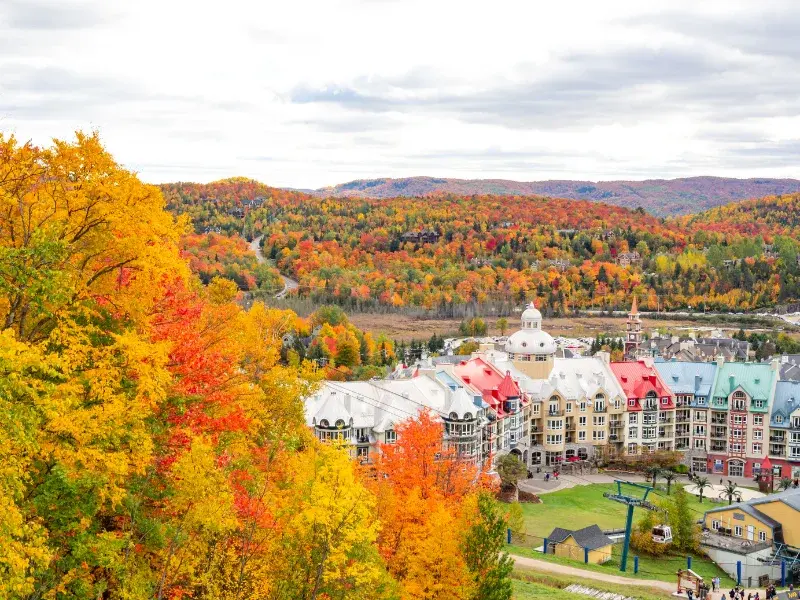 Aerial view of Mont-Tremblant in the Laurentians with autumn-colored trees and colorful rooftops - Best movers Laurentians