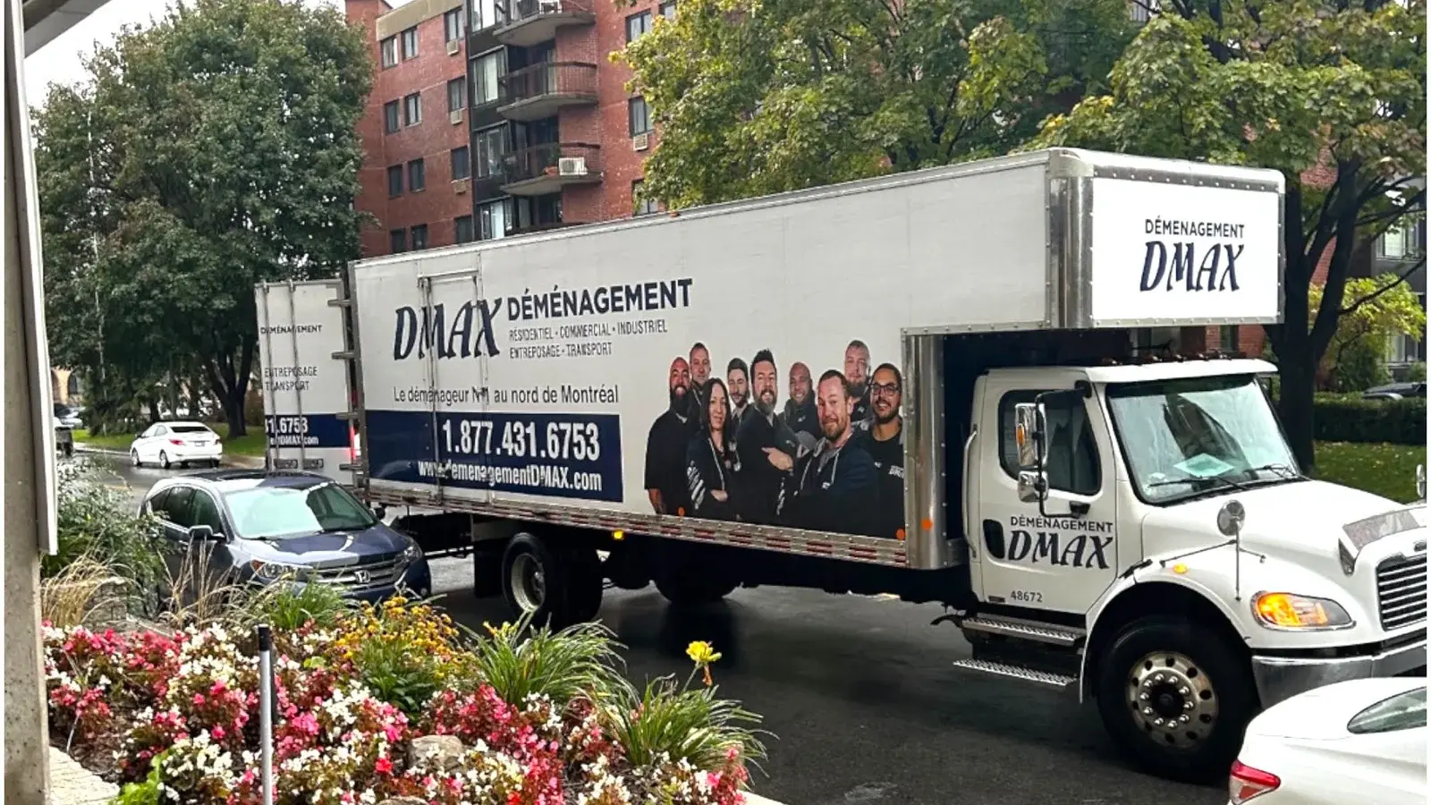 Moving Terrebonne: a Déménagement DMAX truck parked on a residential street, in front of an apartment building
